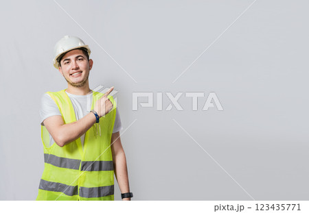 Engineer man pointing to side. Builder engineer pointing finger to the right isolated, Portrait of engineer man pointing aside, Construction engineer with vest pointing at an advertisement 123435771