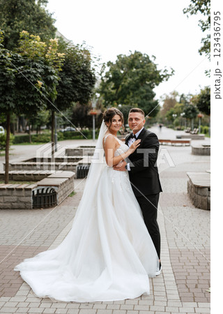 the groom in a brown suit and the bride in a white dress 123436795