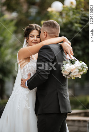 the groom in a brown suit and the bride in a white dress 123436802