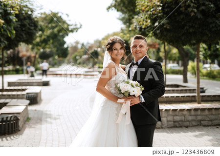 the groom in a brown suit and the bride in a white dress the groom in a brown suit and the bride in a white dress 123436809