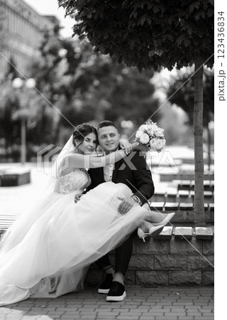 the groom in a brown suit and the bride in a white dress 123436834