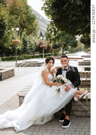 the groom in a brown suit and the bride in a white dress the groom in a brown suit and the bride in a white dress 123436837