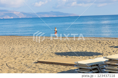 Empty beach with sun loungers and umbrellas in the early morning on a sunny day on the Crete island Greece. 123437118