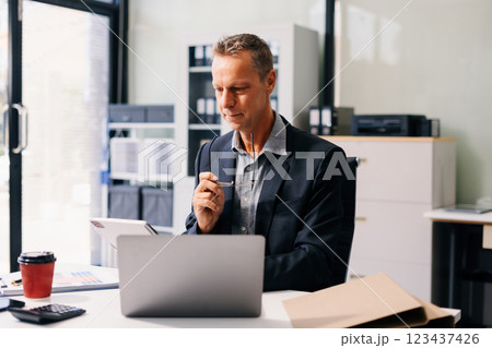Mature businessman using a tablet to analysis graph company financial in office. Mature businessman using a tablet to analysis graph company financial in office. 123437426