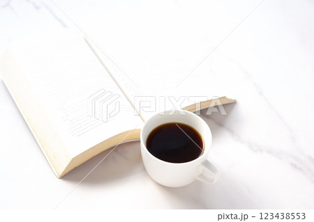 コーヒーを飲みながら、のんびりペーパーバック(洋書)を読んでいるイメージ コーヒーを飲みながら、のんびりペーパーバック(洋書)を読んでいるイメージ 123438553