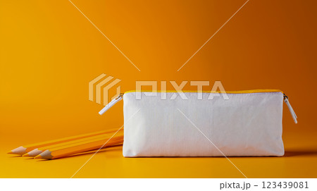 A white pencil case with two yellow pencils on a yellow background A white pencil case with two yellow pencils on a yellow background 123439081