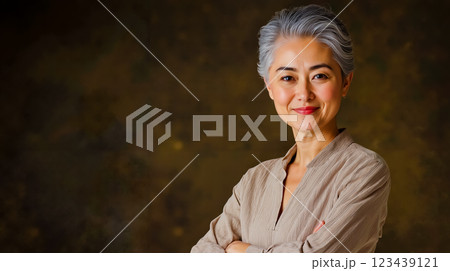 A woman with grey hair and a brown shirt smiles at the camera A woman with grey hair and a brown shirt smiles at the camera 123439121