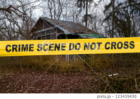 American police tape in front of an abandoned cabin in the woods 123439430