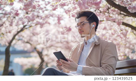 公園のベンチでモバイル会議 – 桜が舞う中で.. 123439525