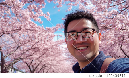 桜並木をバックに満面の笑顔でセルフィ – 春.. 123439711