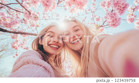 友達と肩を寄せ合ってのセルフィ – 満開の桜.. 123439758