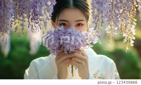 花束で顔を隠す日本人女性と藤の花の庭園 123439866