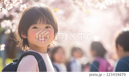 桜の並木道を友達と歩く小学生の優しい表情 123439870
