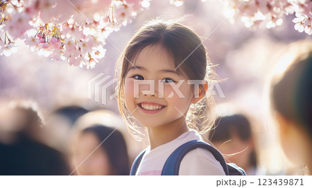 桜の並木道を友達と歩く小学生の優しい表情 123439871