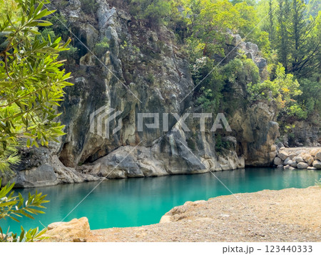 Beautiful mountain river with blue azure water flowing next to rocks in a mountain canyon Beautiful mountain river with blue azure water flowing next to rocks in a mountain canyon 123440333