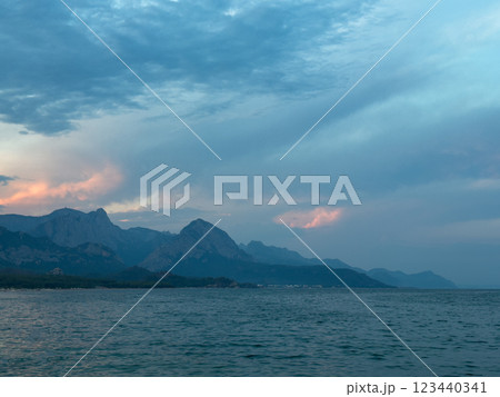 The sea before sunset against a cloudy sky. The bright colors of the sunset are visible through the clouds 123440341