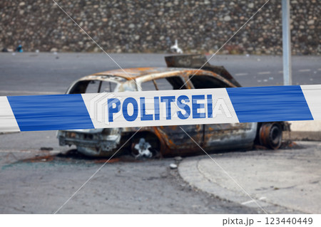 Estonian police tape in front of a burnt car Estonian police tape in front of a burnt car 123440449