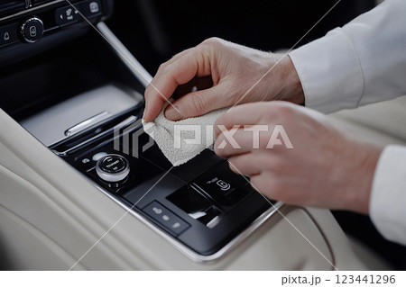 Hands polishing gear console in luxury car 123441296