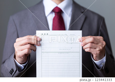 グレーのスーツを着て履歴書を持つミドル男性ビジネスマン 123441333