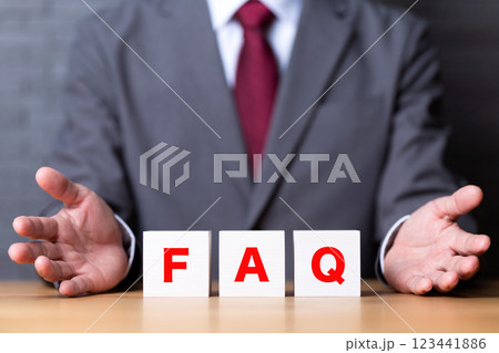 FAQのブロックとスーツを着たミドル男性ビジネスマン FAQのブロックとスーツを着たミドル男性ビジネスマン 123441886