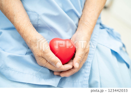 Asian elder senior woman patient holding red heart in hospital. Asian elder senior woman patient holding red heart in hospital. 123442033