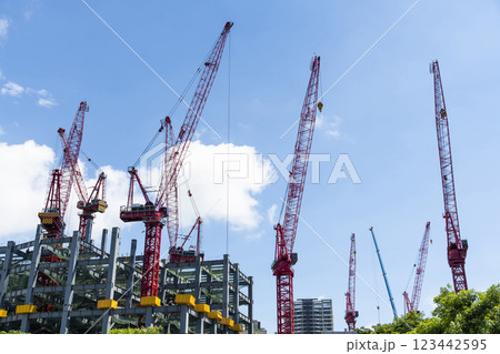 Low-angle view of cranes and steel structures of building construction with a blue sky background in Taiwan. 123442595