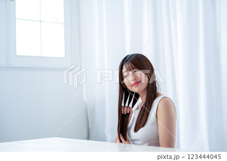 手で髪を梳かす若い女性 手で髪を梳かす若い女性 123444045