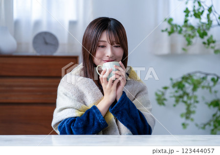 冬のリビングでマグカップを持つ若い女性 123444057