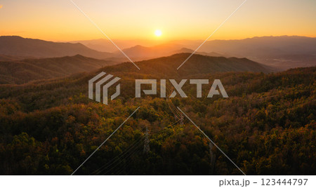 Mountain landscapes reveal scenic sunrises and sunsets painting the sky with clouds over forested hills and valleys 123444797