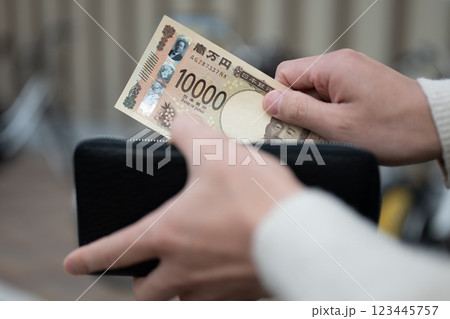 財布からお金を出す男性 123445757