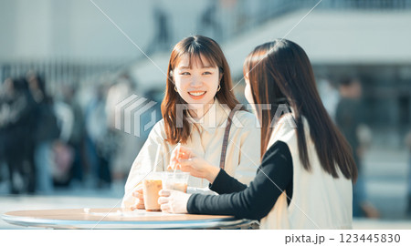 テラス席で飲み物を飲みながら笑顔で話す2人の女性 123445830