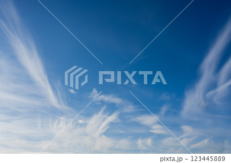 white cirrus clouds around the edge of the image with blue sky in the center 123445889