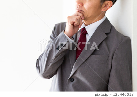 グレーのスーツを着て考え事をするミドル男性ビジネスマン グレーのスーツを着て考え事をするミドル男性ビジネスマン 123446018