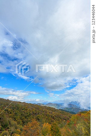 秋の山々と紅葉が織りなす美しい風景、青空と雲が広がる絶景 123446044