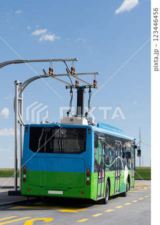 Electric bus at a stop is charged by pantograph. 123446456