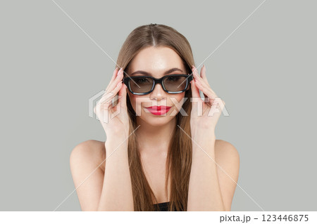 Attractive happy young woman wearing sunglasses posing on white studio background 123446875