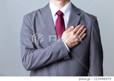 グレーのスーツを着て胸に手を当てるミドル男性ビジネスマン 123446979