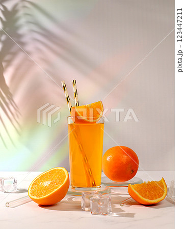 Orange juice and oranges on sunny kitchen table with long hard shadows. Modern still life with citrus fruits, minimal detox diet concept, summer vitamin drinks, selective focus, 123447211