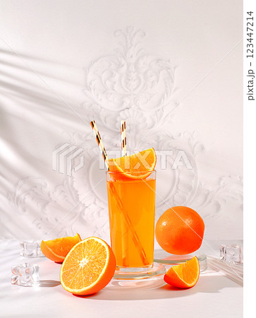 Modern still life with citrus fruits, orange juice and oranges on elegant kitchen table with long hard shadows, minimal detox diet concept, summer vitamin drinks, selective focus Modern still life with citrus fruits, orange juice and oranges on elegant kitchen table with long hard shadows, minimal detox diet concept, summer vitamin drinks, selective focus 123447214