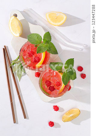 Lemonade cocktail,mojito with tequila, gin, rum, vodka, liqueur, lime, ice and fresh raspberries, bar and party concept, restaurant and cafe advertising card, black background, selective focus 123447288