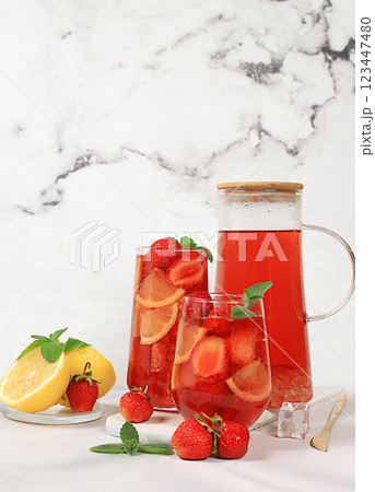 Iced strawberry tea or mint lemon smoothie is a refreshing summer drink recipe. Glass with berry fruit lemonade on a light concrete table, detox diet and weight loss concept, restaurant menu Iced strawberry tea or mint lemon smoothie is a refreshing summer drink recipe. Glass with berry fruit lemonade on a light concrete table, detox diet and weight loss concept, restaurant menu 123447480