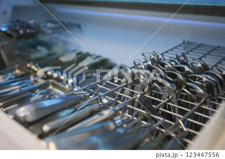 Shiny and polished cutlery resting in a tidy dishwasher basket ready for cleaning 123447556
