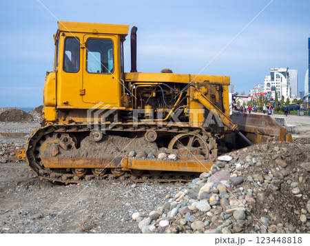 Bulldozer for excavation. Tractor from the Chelyabinsk Tractor Plant. Part of an orange tractor. Soil of pebbles and earth Bulldozer for excavation. Tractor from the Chelyabinsk Tractor Plant. Part of an orange tractor. Soil of pebbles and earth 123448818