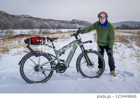 senior male cyclist with a touring electric bike in Colorado foothills in winter scenery senior male cyclist with a touring electric bike in Colorado foothills in winter scenery 123449668