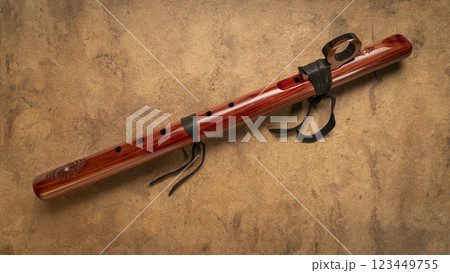 native American style flute handcrafted from aromatic cedar wood against art paper native American style flute handcrafted from aromatic cedar wood against art paper 123449755