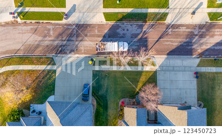 Aerial view above a garbage truck in a residential suburban area in fall morning Aerial view above a garbage truck in a residential suburban area in fall morning 123450723