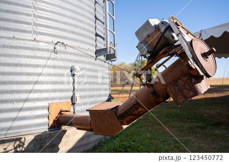 rusted auger unload shoot on a metal grain bins on a family farm. rusted auger unload shoot on a metal grain bins on a family farm. 123450772