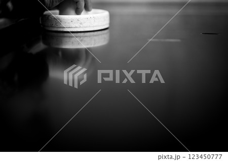 Selective focus on an air hockey table and a small child holding the paddle. Selective focus on an air hockey table and a small child holding the paddle. 123450777