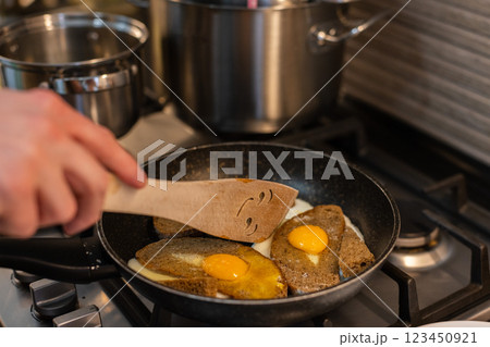 Man cooking fried eggs with croutons for breakfast. Man cooking fried eggs with croutons for breakfast. 123450921