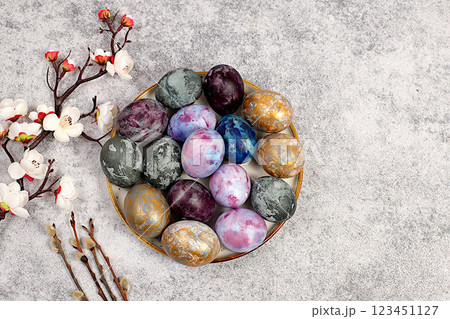 Easter celebration concept, Easter marble eggs dyed with natural hibiscus tea with sakura branch on concrete gray background. holiday card and ideas for preparing for the great holiday 123451127
